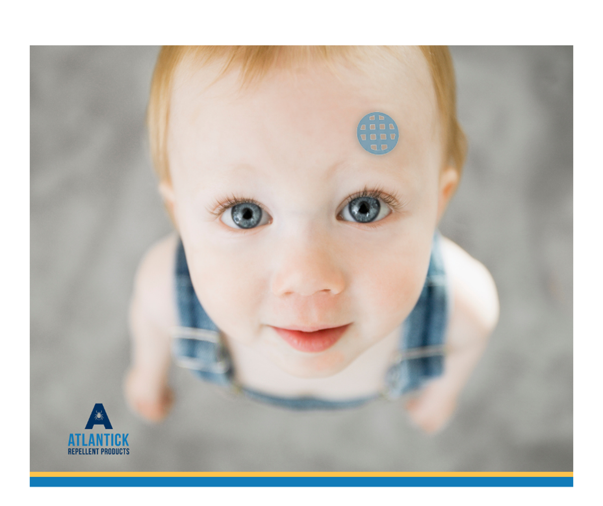 A close-up of a smiling baby with blue eyes, wearing denim overalls, looking up at the camera. A blue AtlanTick Comfort Patch is placed on their forehead, showcasing the patch's gentle, kid-friendly design for safe and effective itch relief.